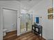 Modern bathroom featuring a glass shower, shiplap walls, and dark wood-look floors at 12492 Eastpointe Dr, Dade City, FL 33525