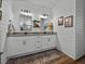 Contemporary bathroom showcasing a double vanity, shiplap walls, and granite counters at 12492 Eastpointe Dr, Dade City, FL 33525
