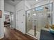 Bright bathroom featuring a tiled shower with glass enclosure and wood-look flooring at 12492 Eastpointe Dr, Dade City, FL 33525
