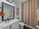 Stylish bathroom with a shower, white vanity, large mirror, and modern fixtures at 12492 Eastpointe Dr, Dade City, FL 33525