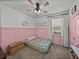 Cozy bedroom with pink wainscoting, a floral futon, and ample natural light at 12492 Eastpointe Dr, Dade City, FL 33525