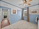Serene bedroom featuring light blue wainscoting, carpet, and access to another room at 12492 Eastpointe Dr, Dade City, FL 33525