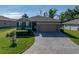 Attractive one-story home with blue shutters, stone accents, a brick driveway, and lush landscaping at 12492 Eastpointe Dr, Dade City, FL 33525