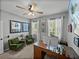 Bright home office with dual windows, wood desk, and cozy armchairs at 12492 Eastpointe Dr, Dade City, FL 33525