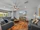 Cozy living room with a large sectional sofa, media console, and sliding glass doors to the backyard at 12492 Eastpointe Dr, Dade City, FL 33525