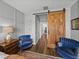 Main bedroom featuring an accent wall, chairs, and a sliding barn door at 12492 Eastpointe Dr, Dade City, FL 33525