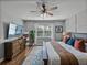 Comfortable main bedroom featuring a TV, ceiling fan, dresser, and a window at 12492 Eastpointe Dr, Dade City, FL 33525