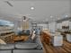 Bright open-concept living area with a kitchen island, comfortable seating, and a media center at 12492 Eastpointe Dr, Dade City, FL 33525