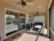 Cozy screened patio with ceiling fans, outdoor seating, and natural light at 12492 Eastpointe Dr, Dade City, FL 33525