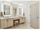 Bright bathroom boasts dual sinks, lighted mirrors, vanity, and a neutral color palette at 1432 50Th Ne Ave, St Petersburg, FL 33703