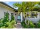 Charming front porch with lush landscaping, a walkway and a sky blue door at 1432 50Th Ne Ave, St Petersburg, FL 33703