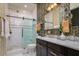 This bathroom features stylish wallpaper and a sleek black vanity with a marble countertop and brass hardware at 1501 W Horatio St # 101, Tampa, FL 33606