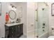 Bathroom featuring a marble countertop, gold fixtures, black cabinets, and a glass-enclosed tub/shower combination at 1501 W Horatio St # 101, Tampa, FL 33606