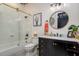 This bathroom features a marble countertop, gold fixtures, black cabinets, and a glass-enclosed tub/shower combination at 1501 W Horatio St # 101, Tampa, FL 33606