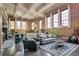 Spacious living room with exposed brick, tall windows, and modern furniture at 1501 W Horatio St # 101, Tampa, FL 33606