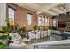 Spacious living area featuring exposed brick, large windows, modern seating, and plants at 1501 W Horatio St # 101, Tampa, FL 33606