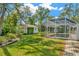 View of the expansive backyard with a screened pool enclosure and a charming shed at 15234 Scanio Dr, Spring Hill, FL 34610