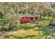 Exterior view of a red barn with lush greenery providing a rustic charm at 15234 Scanio Dr, Spring Hill, FL 34610