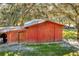 External view of a large red barn with a cupola and lean-to, perfect for storage or livestock at 15234 Scanio Dr, Spring Hill, FL 34610