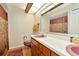 This bathroom features dual sinks, wood-look flooring, and an oversized mirror at 15234 Scanio Dr, Spring Hill, FL 34610