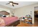 A comfortable bedroom shows a ceiling fan, hard flooring, and adjacent library at 15234 Scanio Dr, Spring Hill, FL 34610