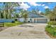 Spacious two-car garage attached to a home with a driveway and green landscaping at 15234 Scanio Dr, Spring Hill, FL 34610