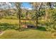 Scenic view of the property featuring a spacious field with a wooden structure in a tranquil setting at 15234 Scanio Dr, Spring Hill, FL 34610