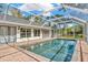 Relax by the screened pool, adjacent to the house with multiple access points and a brick-paved deck at 15234 Scanio Dr, Spring Hill, FL 34610