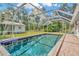 Enjoy the beautiful screened-in pool area with lush surroundings, ideal for outdoor relaxation and entertainment at 15234 Scanio Dr, Spring Hill, FL 34610