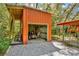 Exterior view of an orange shed with a lawnmower inside, offering convenient outdoor storage at 15234 Scanio Dr, Spring Hill, FL 34610