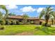 Welcoming single-story home with lush green lawn, mature palm trees, and well-maintained landscaping at 1901 Paddock Dr, Plant City, FL 33566