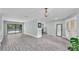 Bright and airy living room with light-gray flooring, neutral paint, and sliding glass doors leading to the pool at 1901 Paddock Dr, Plant City, FL 33566