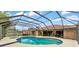 Screened-in pool with spa surrounded by lush landscaping and comfortable seating areas at 1901 Paddock Dr, Plant City, FL 33566