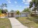 Eye-catching view of a home’s exterior with a driveway, fenced yard, and vibrant landscaping at 1905 E Broad St, Tampa, FL 33610