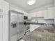 Bright kitchen featuring stainless steel appliances, granite countertops, and ample white cabinetry at 1905 E Broad St, Tampa, FL 33610