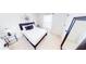 Well-lit bedroom features neutral walls, a plush bed with decorative pillows and two stylish glass side tables at 191 Brofield St, Brooksville, FL 34604