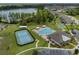 This aerial view showcases community amenities including a pool, tennis and basketball courts, a clubhouse and the lake at 20108 Stone Pine Cir, Lutz, FL 33558