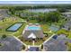 Aerial view of community clubhouse, pool, tennis courts, basketball court, playground and parking area with surrounding trees and lake at 20108 Stone Pine Cir, Lutz, FL 33558
