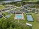 This aerial view showcases community amenities including a pool, tennis and basketball courts, a clubhouse, lake and the homes at 20108 Stone Pine Cir, Lutz, FL 33558