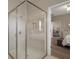 Modern bathroom features a glass enclosed shower and a glimpse of the Primary bedroom at 20108 Stone Pine Cir, Lutz, FL 33558