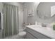 Bathroom featuring a shower and tub with white marble tile surround and gray vanity at 20108 Stone Pine Cir, Lutz, FL 33558