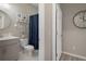 Neutral bathroom with a framed round mirror, gray vanity, framed art, and blue shower curtain at 20108 Stone Pine Cir, Lutz, FL 33558