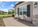 Inviting front porch featuring comfortable seating, decorative stone accents and manicured landscaping at 20108 Stone Pine Cir, Lutz, FL 33558