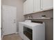 Bright laundry room with white cabinets, shelves, a washer, and a dryer at 20108 Stone Pine Cir, Lutz, FL 33558