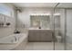 Elegant main bathroom featuring a soaking tub, double vanity, and glass shower at 20108 Stone Pine Cir, Lutz, FL 33558