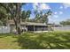 Backyard with fenced-in porch and mature trees at 2044 Balfour Cir, Tampa, FL 33619