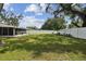 Spacious fenced backyard featuring an enclosed patio and mature trees at 2044 Balfour Cir, Tampa, FL 33619