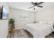 Airy bedroom with a large TV, hardwood floors, a large window, and modern accents at 2044 Balfour Cir, Tampa, FL 33619