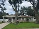 Charming single-story home featuring a well-manicured lawn and mature trees at 2044 Balfour Cir, Tampa, FL 33619