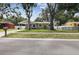 Charming one-story home featuring a well-maintained lawn and a cozy carport area with outdoor seating at 2044 Balfour Cir, Tampa, FL 33619
